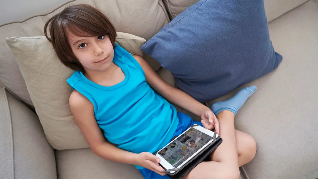 niño lee comic en tablet
